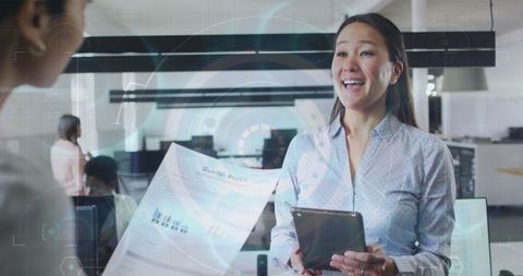 Businesswoman Using Tablet Overlaid with Financial Graphics