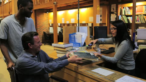 Student Assists Disabled Peer in Wheelchair at Library