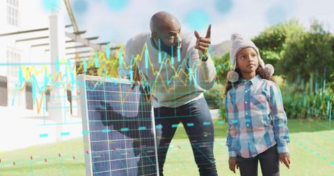 Man teaching girl with solar panel and energy graphs overlay in suburban yard