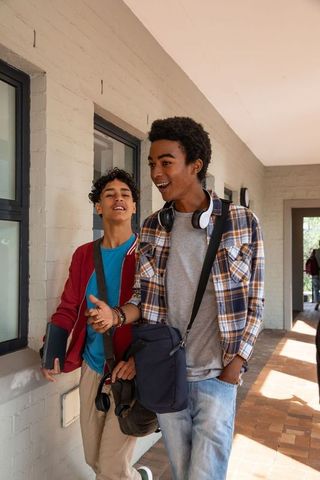 Friends Discussing Technology While Walking in Urban Corridor