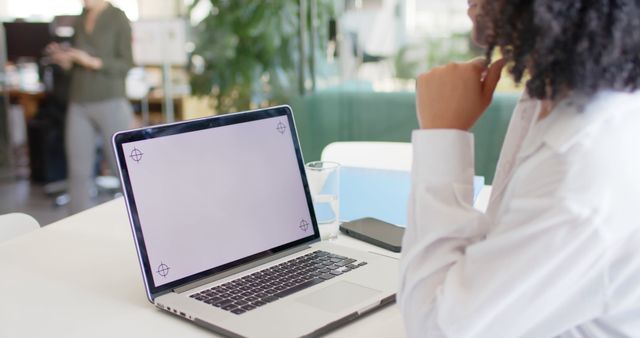 Businesswoman Contemplating Work on Laptop in Modern Office - Download Free Stock Images Pikwizard.com