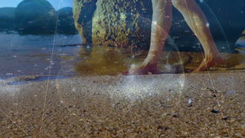 Digital Globe Overlay on Man Walking Barefoot on Beach Sand