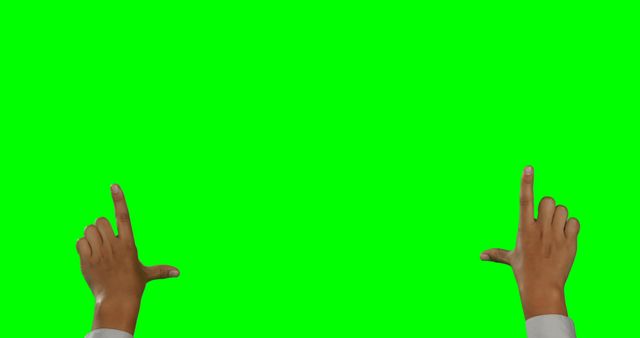 Close-up of hands framing a scene against a vibrant green screen backdrop. Useful for tutorials, instruction manuals, sign language demonstrations, or any projects requiring a chroma key background to superimpose images or videos.