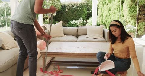 Couple Tidying Up After Celebration in Living Room