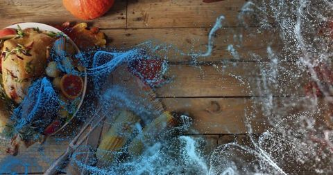 Roasted chicken sitting on rustic wood table with abstract blue particle swirls