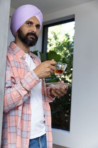 Man Wearing Turban Enjoying Tea at Home in Relaxed Setting