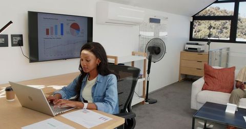 Professional in Modern Office Analyzing Data on Laptop and Display