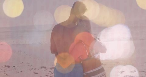 Couple embracing on beach during sunset with inflatable ring
