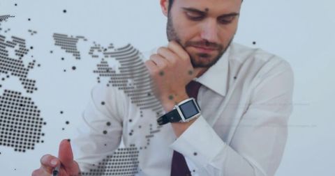 Contemplating executive planning global strategy with smartwatch and dotted world map