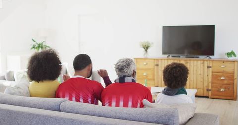 Family Bonding in Living Room Watching Soccer Game on TV
