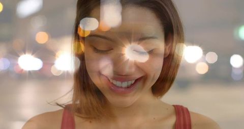 Cheerful Woman Posing with Nighttime City Bokeh Lighting