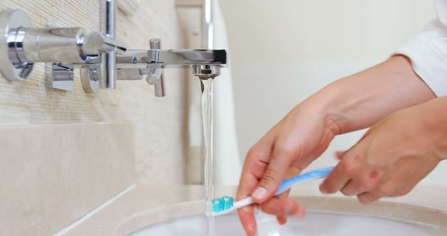 Person Brushing Teeth at Modern Bathroom Sink with Flowing Water - Download Free Stock Images Pikwizard.com