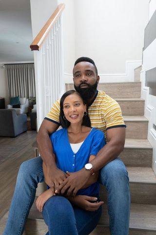 Cozy Couple Sitting on Home Staircase Demonstrating Affection