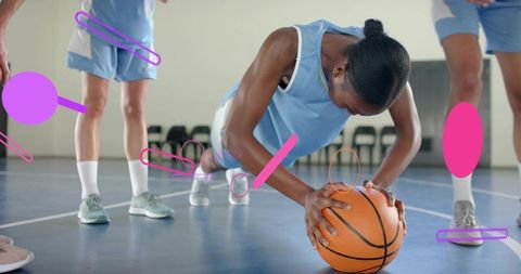 Gripping basketball holding plank during women's team training on indoor court