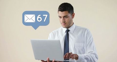 Businessman focused on laptop with email notification bubble