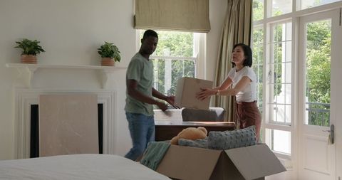 Happy Couple Unpacking in New Home with Sunlit View