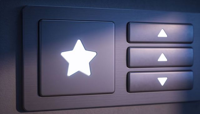 Backlit star button with up and down arrow controls on brushed metal control panel