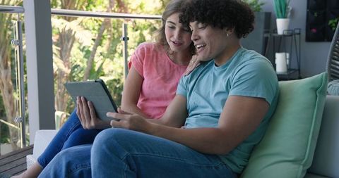 Young Couple Enjoying Digital Time Together on Balcony