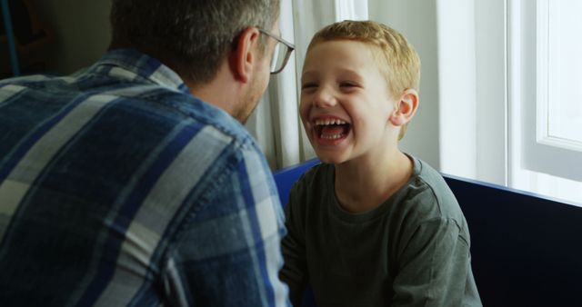 Father and Son Sharing Quality Time and Laughter Near Window - Download Free Stock Images Pikwizard.com