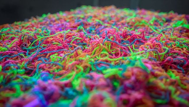 Bursting neon tangles: macro close-up yarn texture showcasing vibrant multicolored fiber pile