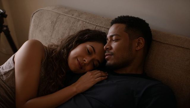 Couple cuddling on sofa sharing intimate cozy evening at home lifestyle romance warm tones