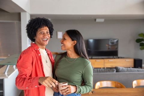 Smiling Couple Relaxing at Home Holding Cups