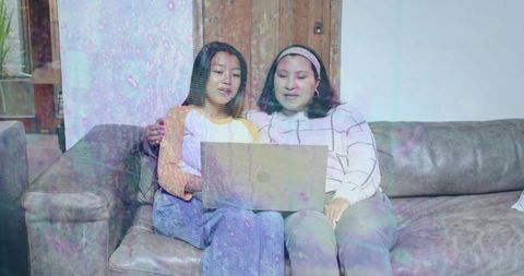 Mother and Daughter Browsing Laptop on Living Room Couch Sharing Cozy Family Bonding