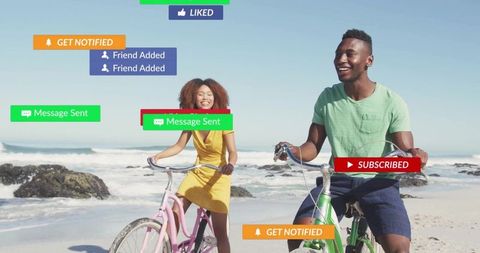 Couple cycling along sunny beach with social media notifications overlay, vibrant bicycles