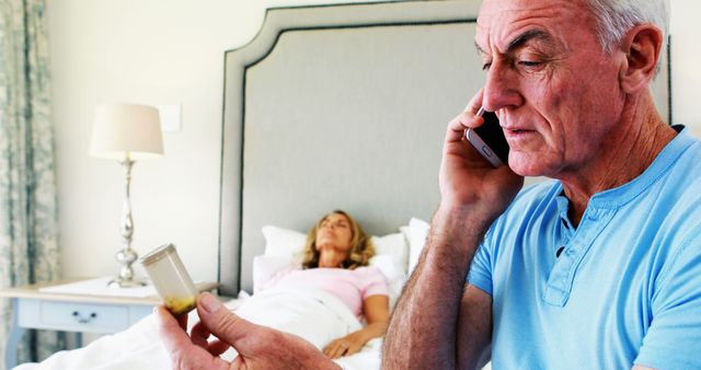 Concerned Senior Man Holding Medication Bottle and Calling on Phone in Bedroom - Download Free Stock Images Pikwizard.com