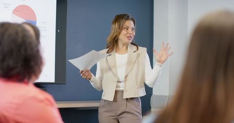 Indian presenter leading team presentation with pie chart in corporate boardroom