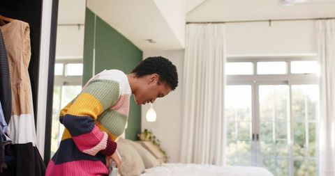 Person Tidying up Modern Bedroom with Colorful Touches