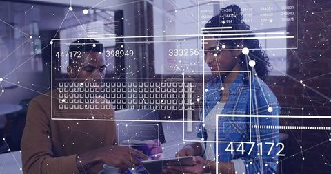 Tech professionals analyzing data on tablet in office