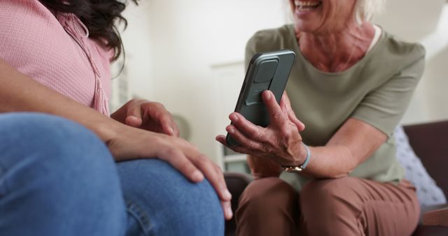 Smiling elderly woman showing something on smartphone to female friend - Download Free Stock Images Pikwizard.com