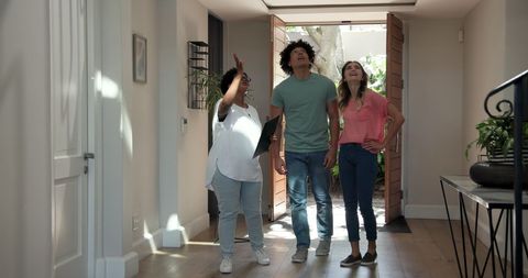 Cheerful real estate agent welcoming couple to new home