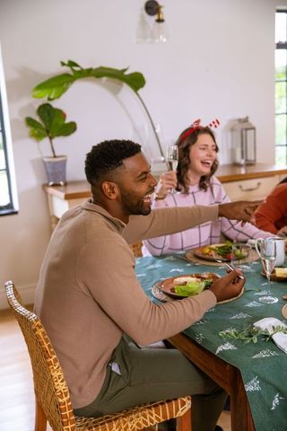 Diverse Friends Celebrating with Laughter at Cozy Dining Table