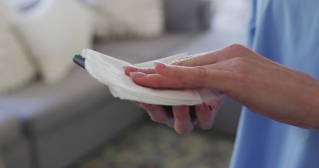 Person Cleaning Smartphone with Disinfectant Wipe - Download Free Stock Images Pikwizard.com