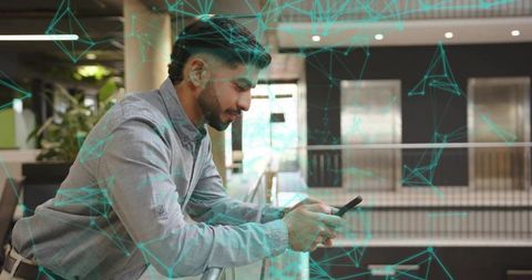 Businessman Engaged with Smartphone in Modern Office Surroundings