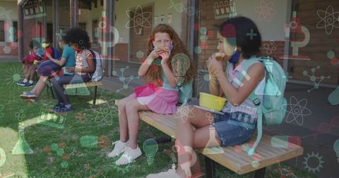 Schoolchildren Wearing Masks Eating Outdoors On Bench