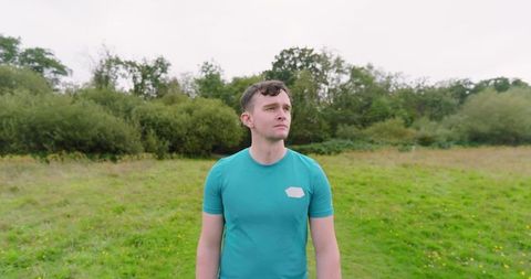 Man in Green Shirt Walking in Lush Park Enjoying Nature - Download Free Stock Images Pikwizard.com