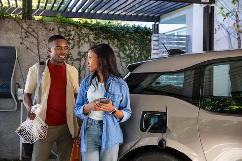 Couple Charging Electric Car at Home, Embracing Eco-Friendly Lifestyle