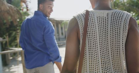 Joyful couple arriving at beachfront house on sunny day