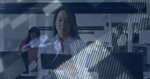 Focused asian businesswoman with tablet in collaborative workspace