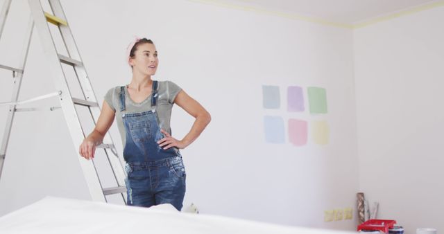 Woman in Denim Overalls Choosing Wall Paint Colors - Download Free Stock Images Pikwizard.com