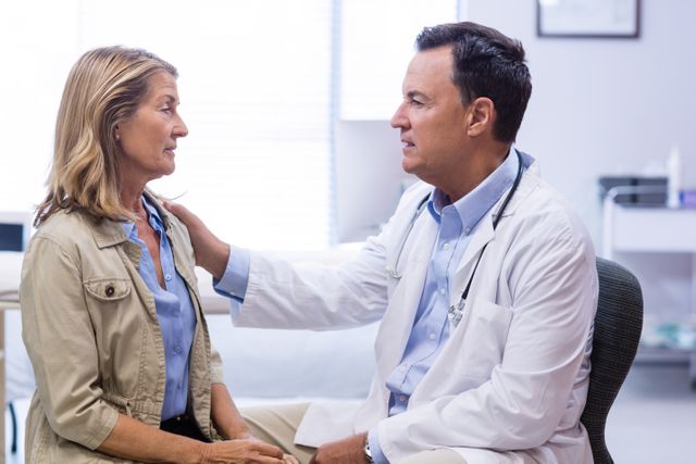 Doctor consoling senior woman in clinic, showing empathy and support. Ideal for healthcare, medical, and elderly care themes. Can be used in articles, brochures, and websites promoting compassionate patient care and medical services.