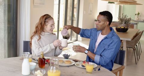 Diverse Couple Enjoying Breakfast Together in Cozy Kitchen Setting