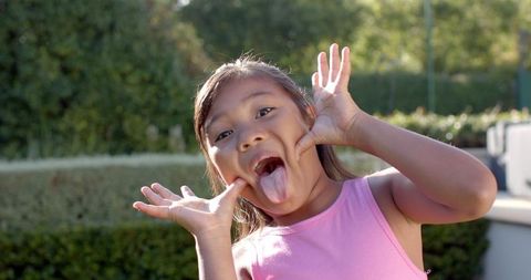 Joyful Girl Making Silly Faces Outdoor on Sunny Day