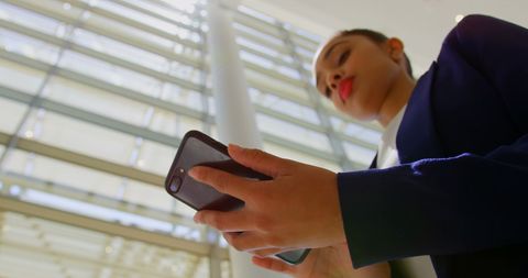 Businesswoman browsing smartphone technology indoors