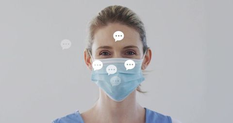 Smiling nurse wearing surgical mask and scrubs communicating patient care with speech bubbles