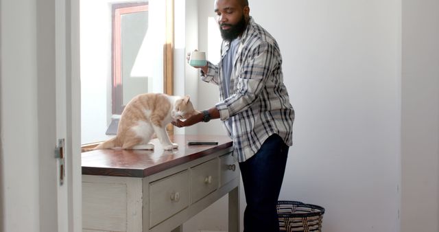 Man drinking coffee while petting cat in cozy morning scene - Download Free Stock Images Pikwizard.com