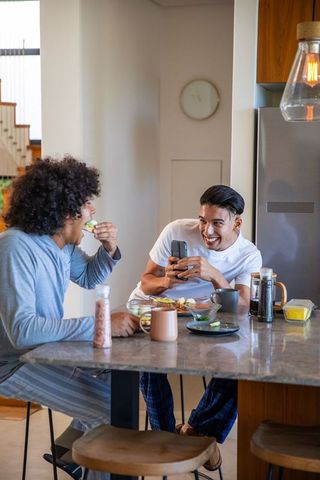 Friends enjoying avocado toast and coffee at modern kitchen island